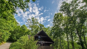 A cabin with a wooden deck, surrounded by dense forest. - Mtn. View, Hot Tub, Dwntwn Avl & Biltmore 15-20 min, WiFi, Serenity at its best! (Fairview)