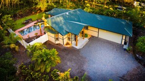 A house with a swimming pool, surrounded by lush greenery. - Affordable Luxury on Kaloli Point.  (Keaau)
