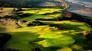 A golf course with a view of the ocean and distant mountains. -  Beach House W Ocean Views, 3 Golfer en suites, hot tub, fireplace, Pets OK! (Bandon)