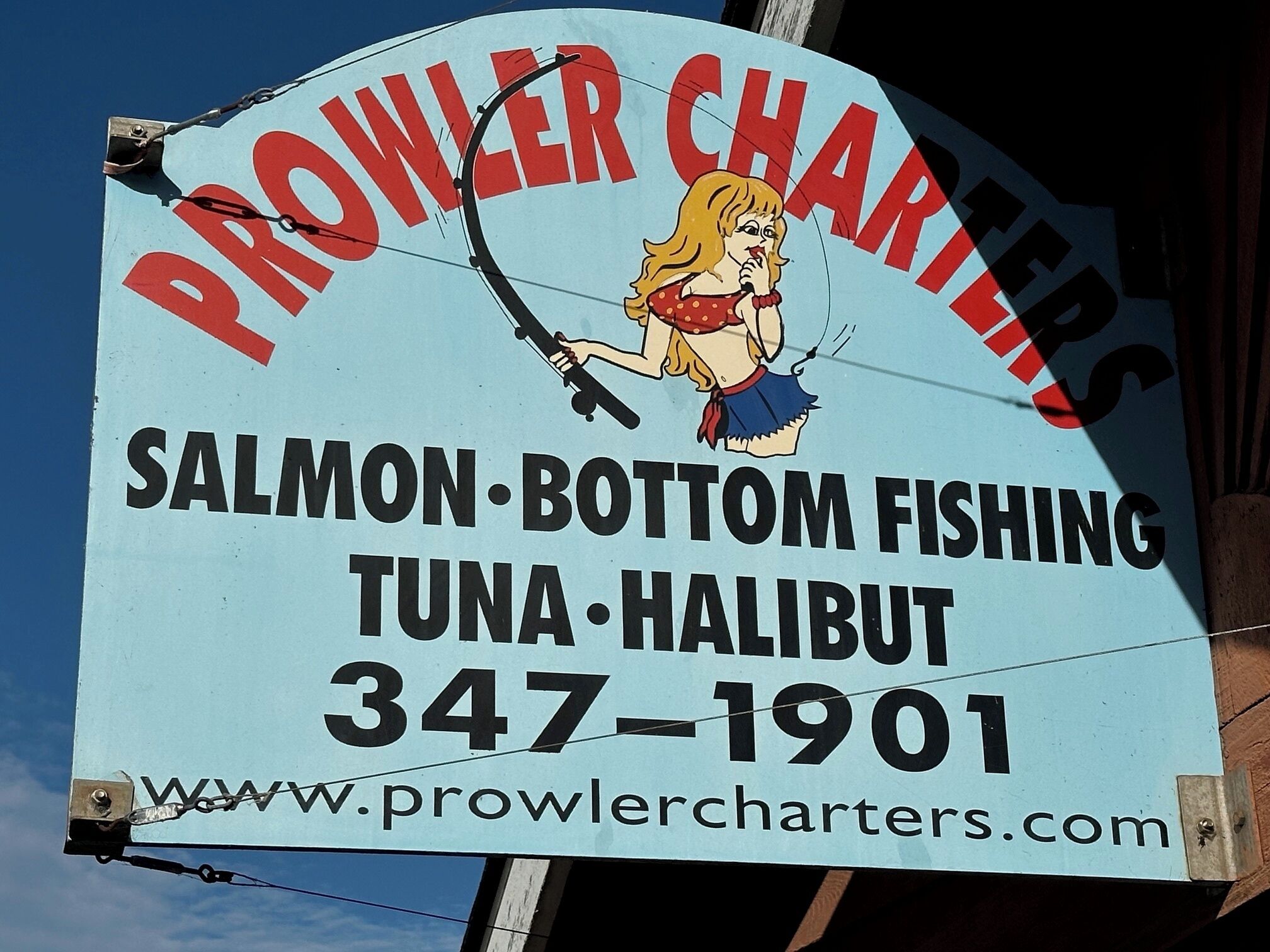 A sign for Prowler Charters, offering salmon, bottom fishing, tuna, and halibut.