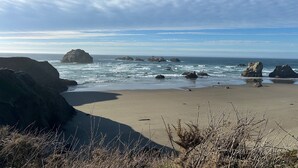 A coastal beach with rocky outcrops and a clear sky. -  Beach House W Ocean Views, 3 Golfer en suites, hot tub, fireplace, Pets OK! (Bandon)