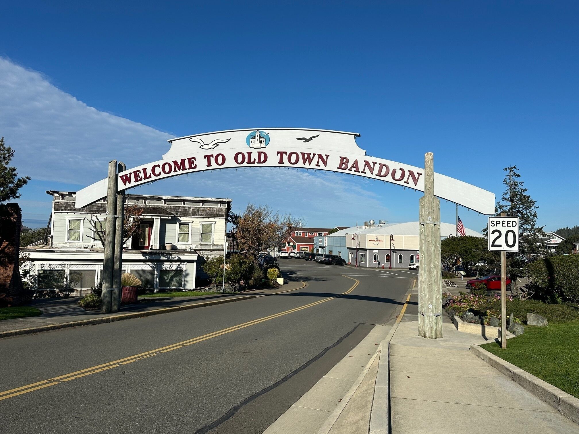 Een bord dat bezoekers verwelkomt in Old Town Bandon, met een snelheidslimiet van 20.