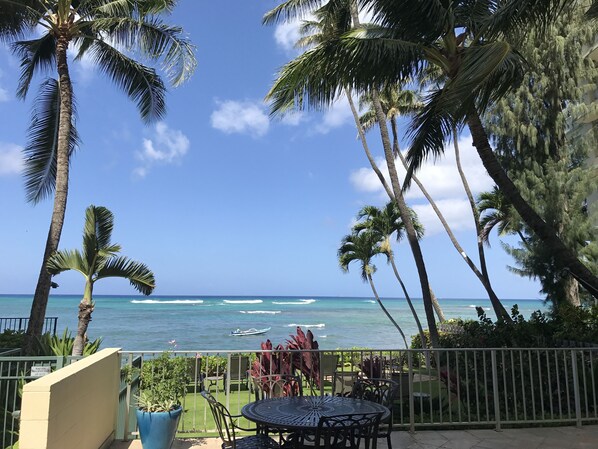 A balcony with a view of the ocean, palm trees, and a table with chairs. - Impeccable Penthouse - Ocean & Diamondhead Views (Honolulu)