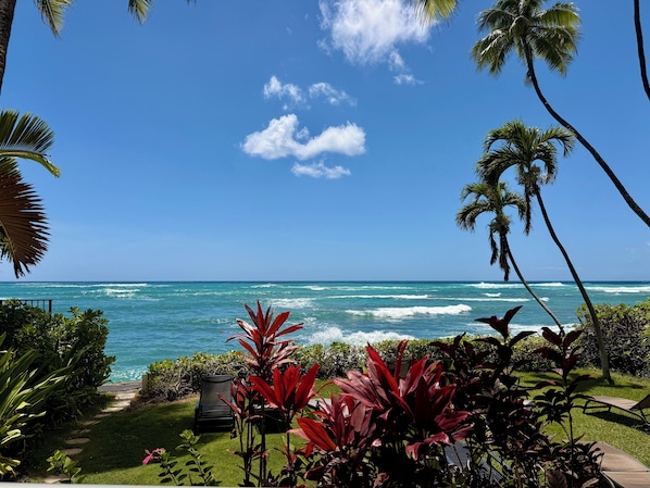 A view of the ocean with waves, a clear sky, and tropical vegetation. - Impeccable Penthouse - Ocean & Diamondhead Views (Honolulu)