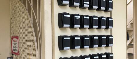 A wall-mounted panel with numbered call buttons, a notice sign, and a barred entrance.