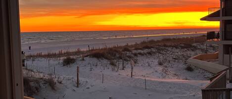 Un balcone con vista sulla spiaggia al tramonto.