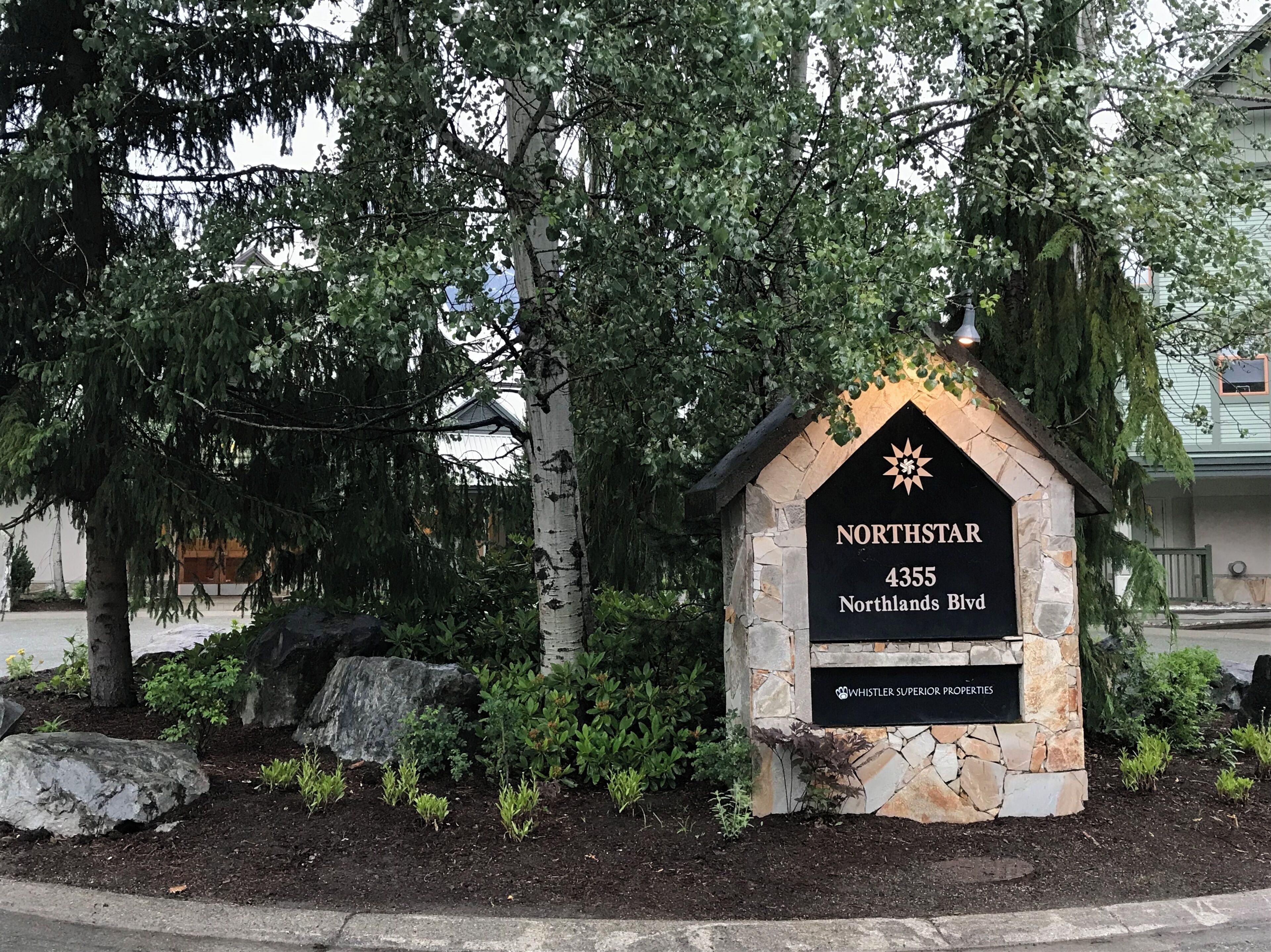 A stone sign with the text 'NORTHSTAR 4355 Northlands Blvd' and 'WHISTLER SUPERIOR PROPERTIES' indicating a property location.