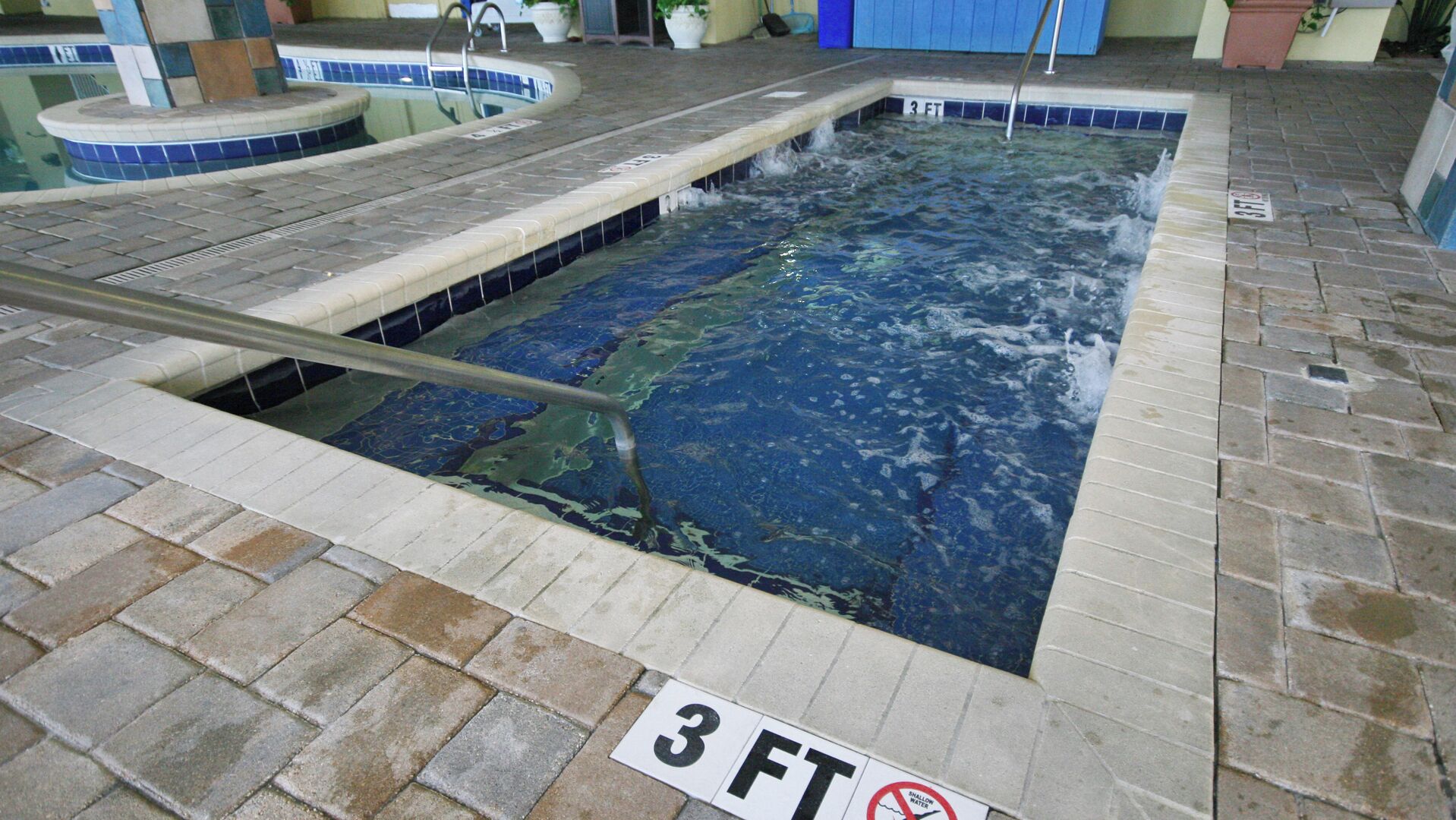 A swimming pool with a 3 FT depth marker and a no-swimming sign.