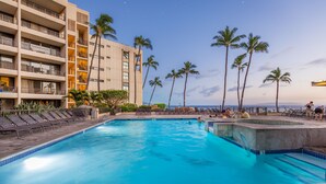 A hotel pool area with multiple levels, palm trees, and a clear view of the ocean. -  Beachfront ,Ground floor, Sugar Beach, Corner  unit 114 - Steps to the Ocean!!! (Kihei)