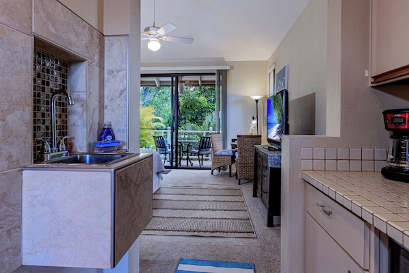 A modern kitchen with a built-in sink, a ceiling fan, and a dining area with a view of the outdoors.