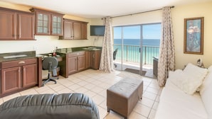 A hotel room with a kitchenette, a sofa, a dining table, and a view of the ocean. - AVAILABLE:4/12-4/19/895 /7 night/Couples Retreat/ balcony over looking beach (Panama City Beach)