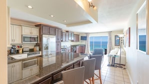 A spacious kitchen with granite countertops, stainless steel appliances, and a large island with bar stools. - AVAILABLE:4/12-4/19/895 /7 night/Couples Retreat/ balcony over looking beach (Panama City Beach)
