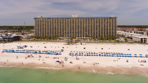 A large hotel with multiple floors and a beach in the foreground. - AVAILABLE:4/12-4/19/895 /7 night/Couples Retreat/ balcony over looking beach (Panama City Beach)