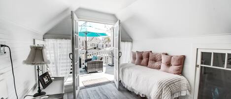 Ein Schlafzimmer mit Bett, Schreibtisch und Fenster.