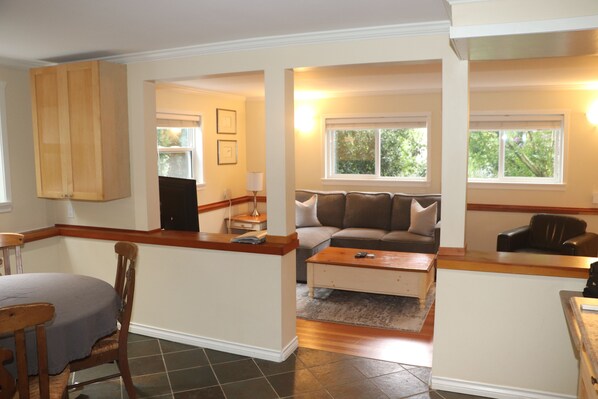 A living room with a sofa, a coffee table, and a dining area with a table and chairs.