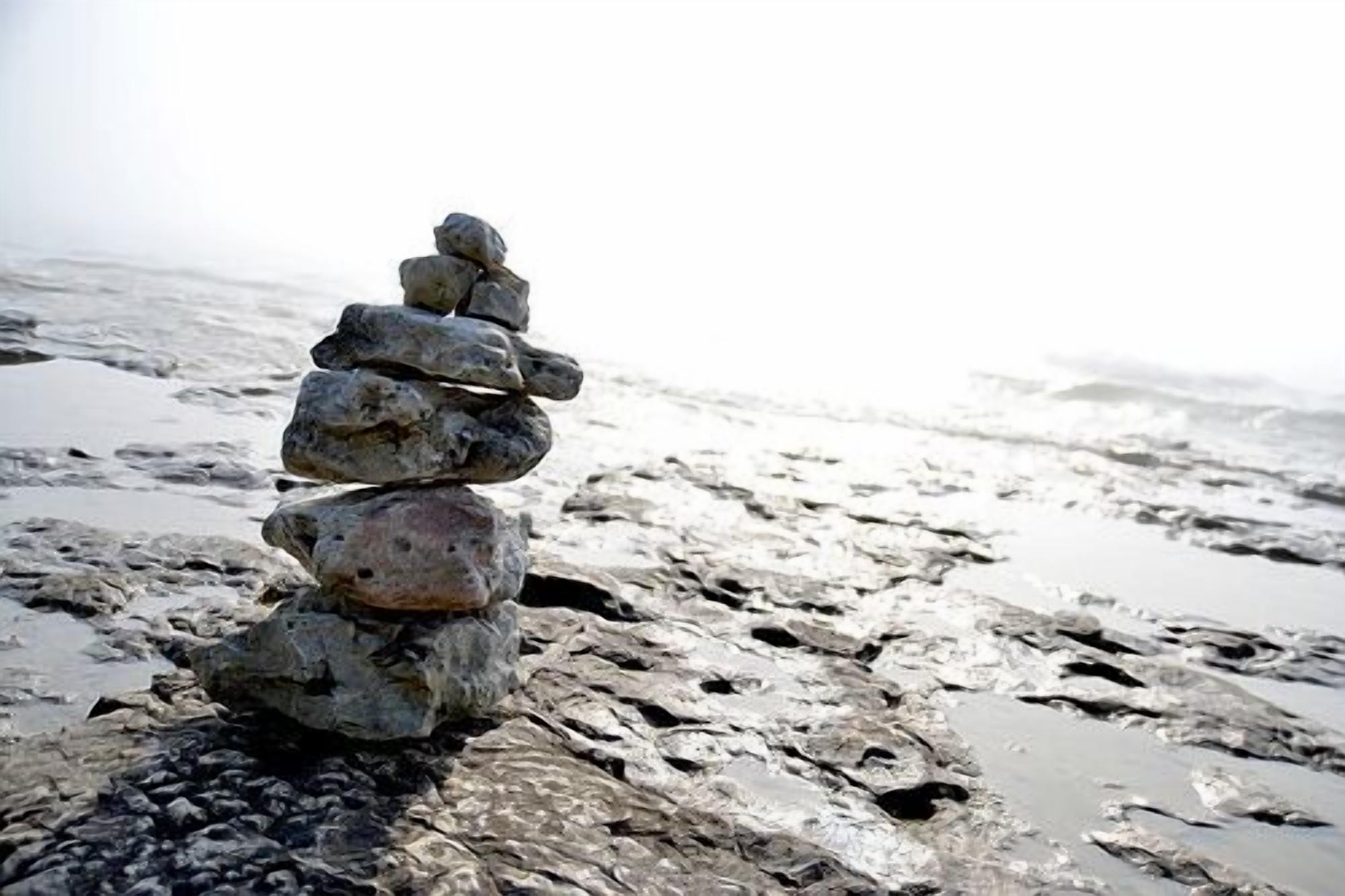 Una pila de rocas sobre una playa rocosa y húmeda.