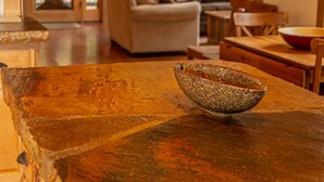 Ein rustikales Interieur mit einem Holztisch, einer Schüssel, einer Couch und einem Essbereich.