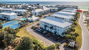A coastal hotel with multiple buildings, a tennis court, and a parking area. - The best beach views from condo of crystal white sand beach (Seagrove Beach)