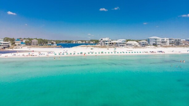 A coastal hotel with multiple buildings, a beach, and clear turquoise waters. - The best beach views from condo of crystal white sand beach (Seagrove Beach)