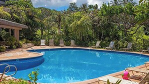 Une piscine avec des chaises longues et une terrasse en pierre.
