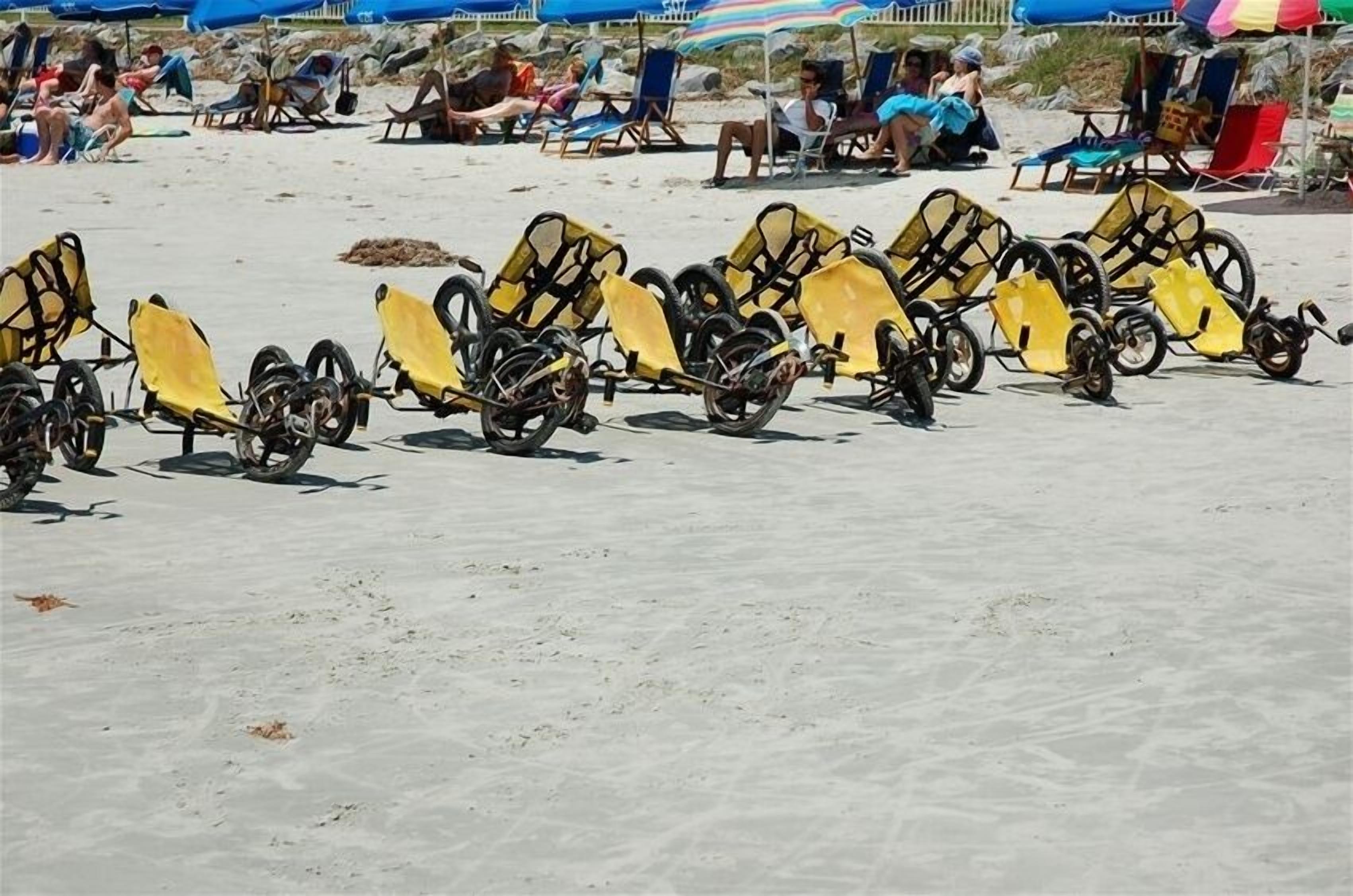 Ein Strand mit Reihen gelber Liegestühle und Sonnenschirme.
