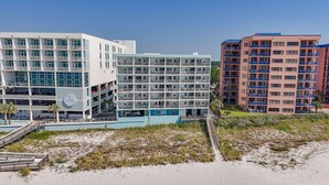 A beachfront hotel with multiple floors, balconies, and a pool area. - Million Dollar View from Your Balcony! (Orange Beach)