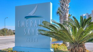 A sign for Emeraliskye with the number 26034, surrounded by palm trees and flowers. - Million Dollar View from Your Balcony! (Orange Beach)