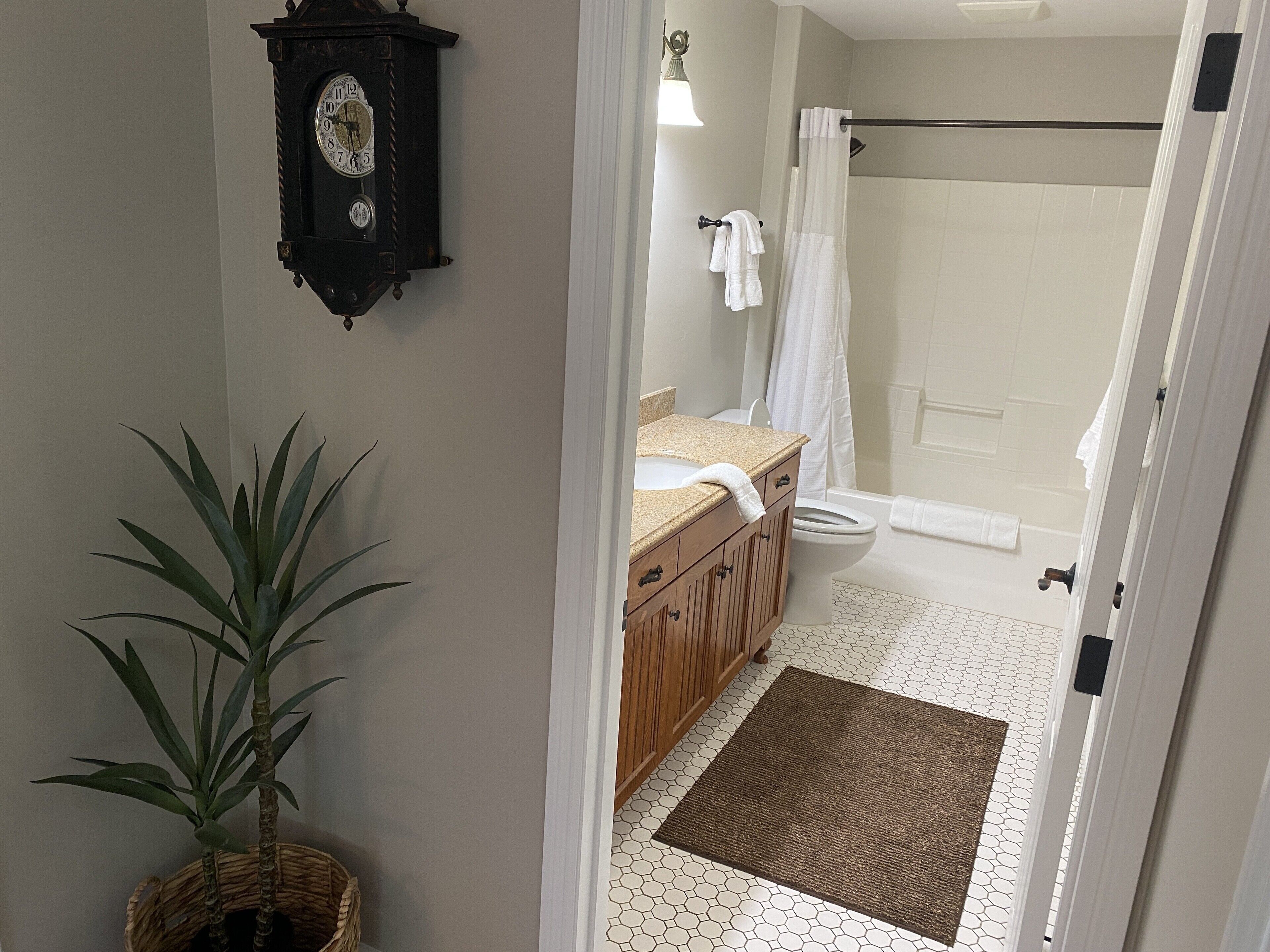 A bathroom with a wooden vanity, a sink, a toilet, and a shower area.