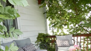 Une terrasse en bois avec un canapé, des chaises et une table.