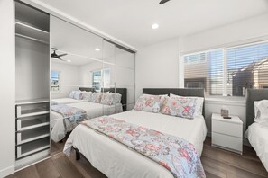 A modern bedroom with two beds, a large mirror, and a window with blinds. - Right on the Famous Mission Beach Boardwalk - Sleeps up to 10 on Top Floor - Best location in Mission Beach (San Diego)
