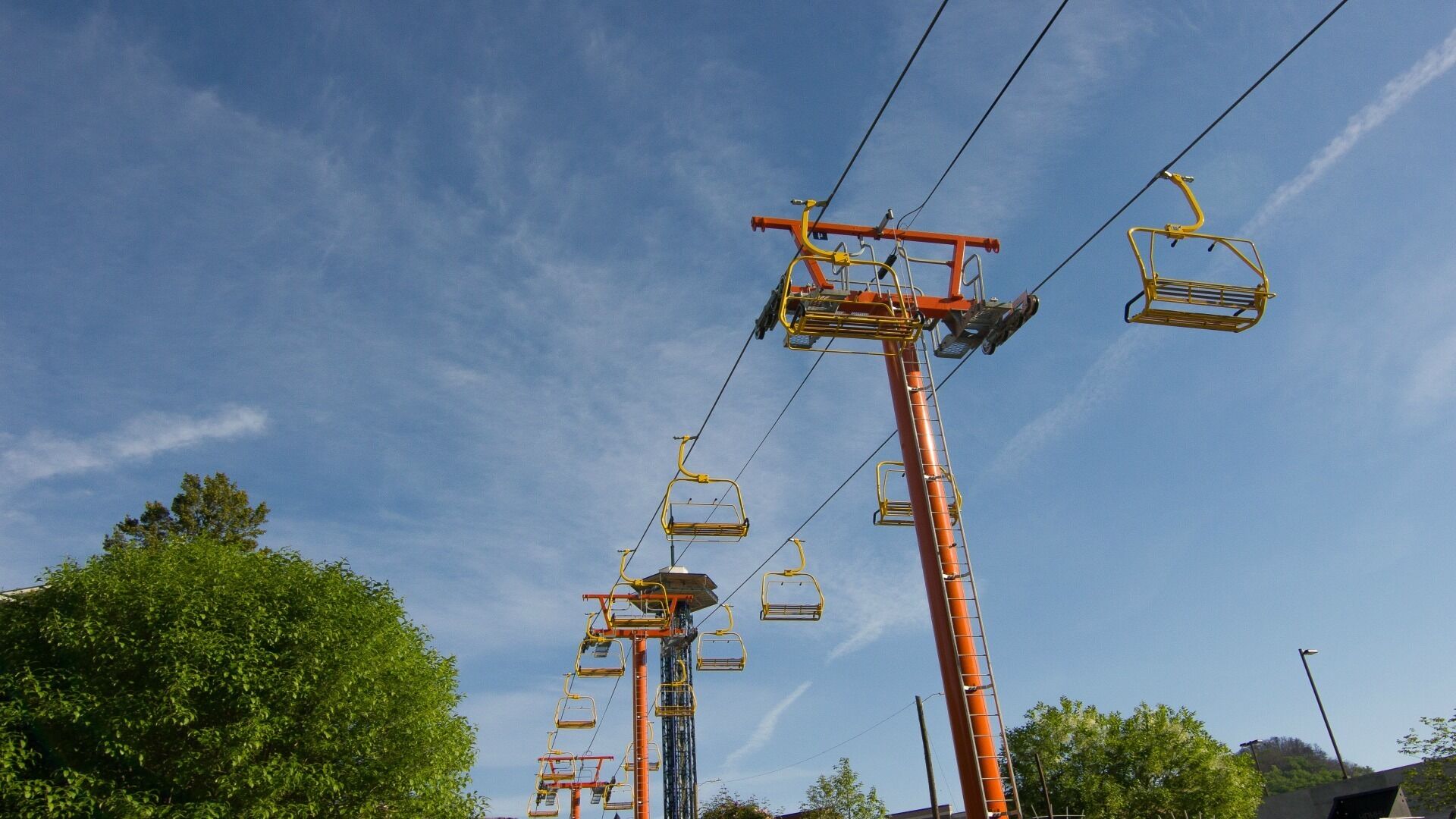 A cable car system with multiple gondolas suspended from a central tower.