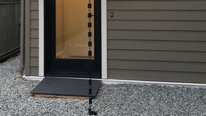 A house with a black front door, a small porch, and a security chain.