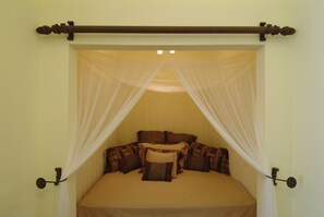 A bed with a canopy, pillows, and a headboard.