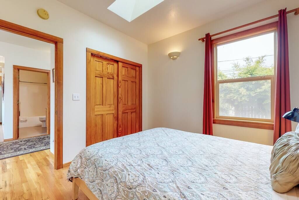 Una camera da letto con un letto, un armadio in legno e una finestra con tende.