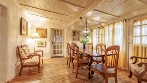 A dining area with wooden furniture, a chandelier, and a door with glass panels.