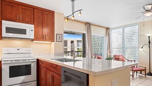 A modern kitchen with wooden cabinets, a white stove, and a built-in dishwasher.