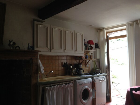 A kitchen with white cabinets, a washing machine, and a window with curtains. - Charming home in Champagne Vineyards Near sezanne (Broyes)