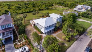 Uma área residencial costeira com casas, praia e céu claro.