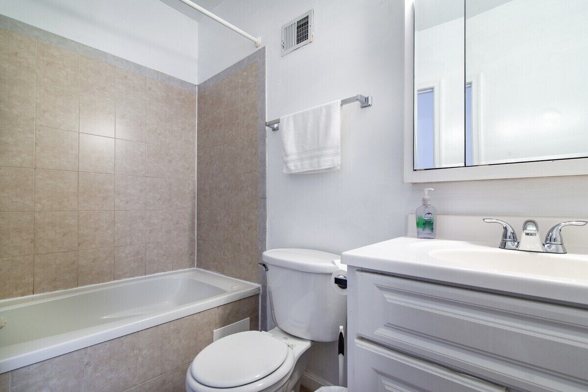 A bathroom with a bathtub, toilet, and sink.