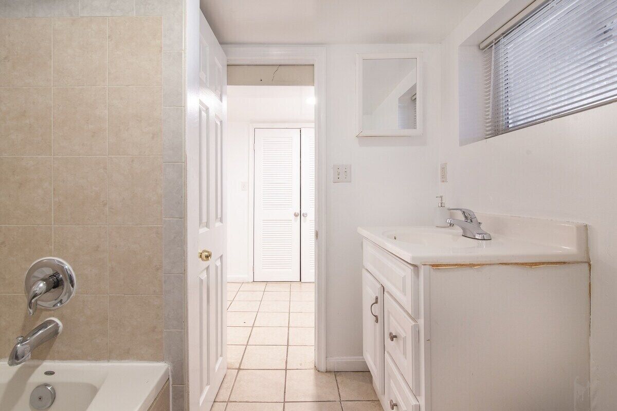 Un bagno con una vasca, un lavandino e uno specchio.