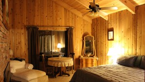 A cozy wooden room with a bed, a chair, a table, and a mirror. - Spa, Quiet, Peaceful Near Rollins Lake, Local Hiking, Romantic, Reunion, Retreat (Gold Run)