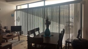 Un coin repas avec une table, des chaises et un vase de fleurs.
