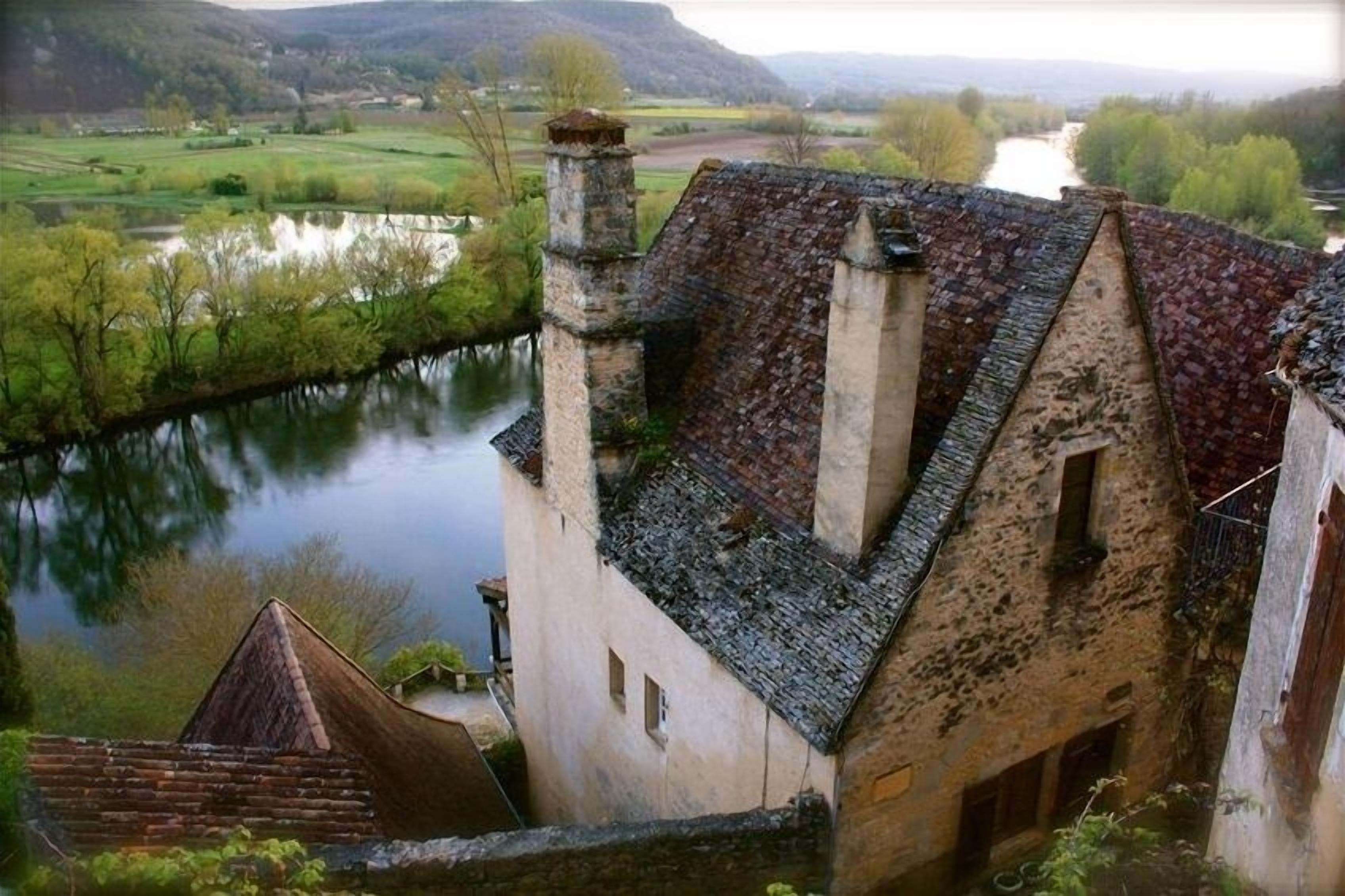 Ein traditionelles Steinhaus mit einem steilen Dach, einem Schornstein und einem kleinen Fenster.