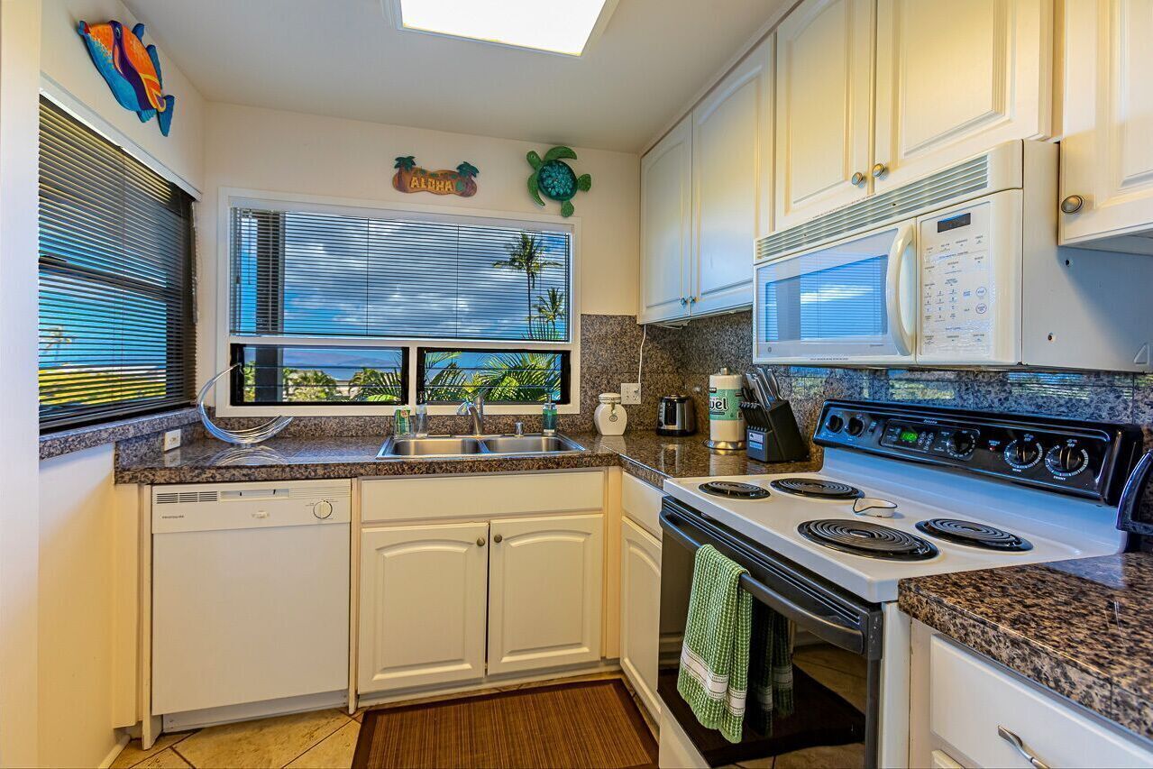 A kitchen with white cabinets, a stove, a microwave, and a dishwasher.