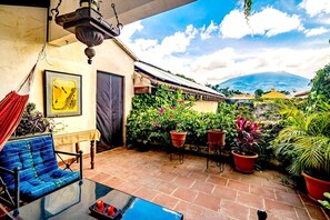A patio with a hammock, a table, and potted plants. - Unique Central & Beautiful home (views to die for from Balcony!) (Antigua Guatemala)
