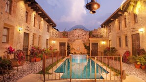 A courtyard with a pool, stone buildings, and potted plants. - Unique Central & Beautiful home (views to die for from Balcony!) (Antigua Guatemala)