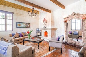 A living room with a fireplace, sofas, a coffee table, and a large mirror. - Unique Central & Beautiful home (views to die for from Balcony!) (Antigua Guatemala)