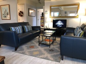 Relax in this inviting living space with a comfortable sofa, coffee table, and bookshelf.