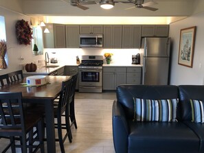 Enjoy cooking in the well-equipped kitchen with a central island, microwave, oven, refrigerator, and gas stove.