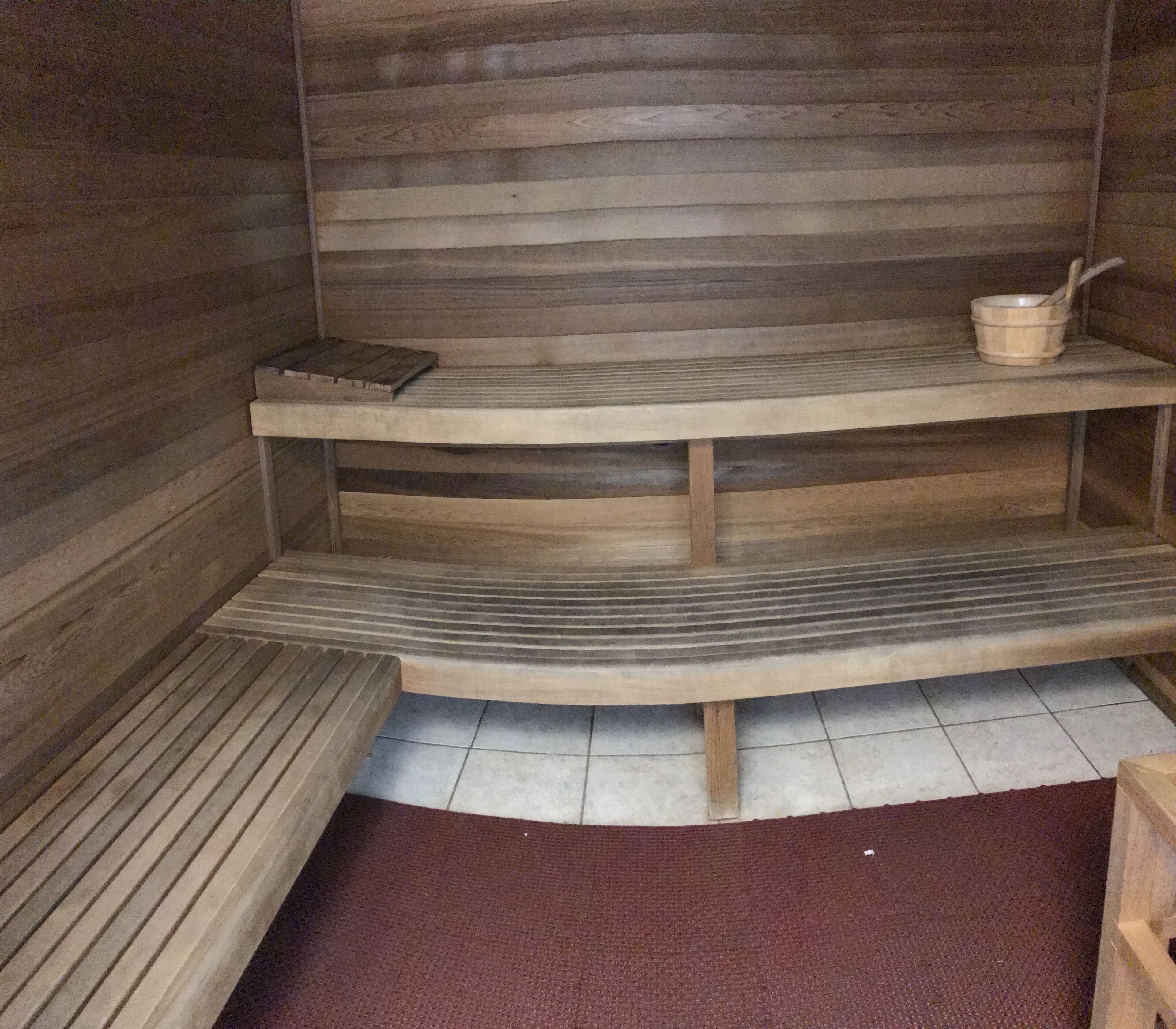 Ein Saunaraum mit Holzbänken und Ablagefläche.